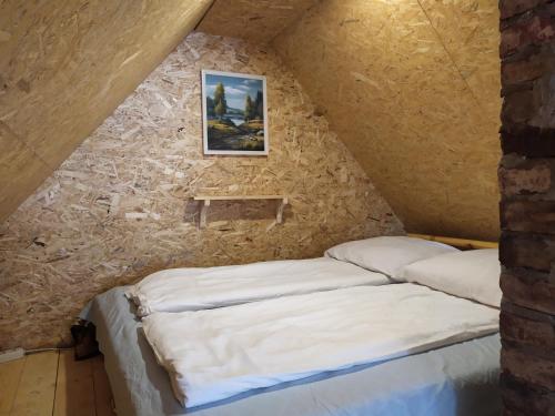 a bed in a room with a stone wall at Ele kodumajutus in Pärnu