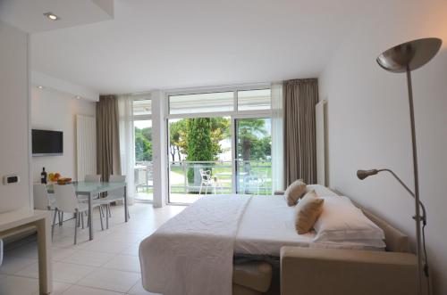1 dormitorio con 1 cama grande y comedor en Club Nautico - Phoenix Studio Lake View, en Riva del Garda