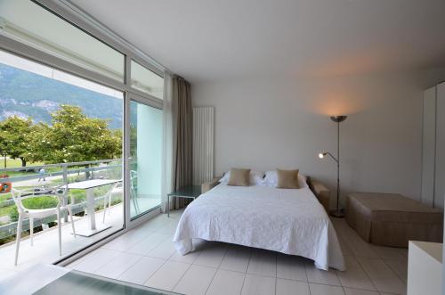 1 dormitorio con cama blanca y ventana grande en Club Nautico - Phoenix Studio Lake View, en Riva del Garda