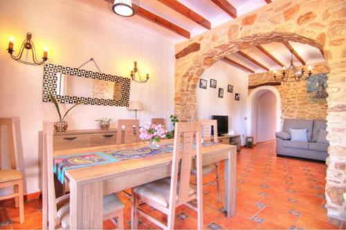 a dining room with a wooden table and chairs at Chalet con piscina privada en Calpe - Terrasala in Casas de Torrat