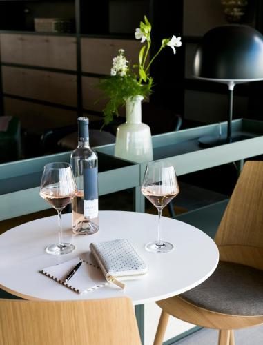 a white table with two glasses and a bottle of wine at OKKO Hotels Lyon Centre in Lyon