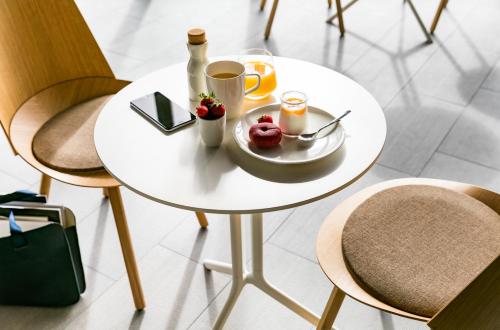 a white table with a plate of food on it at OKKO Hotels Lyon Centre in Lyon
