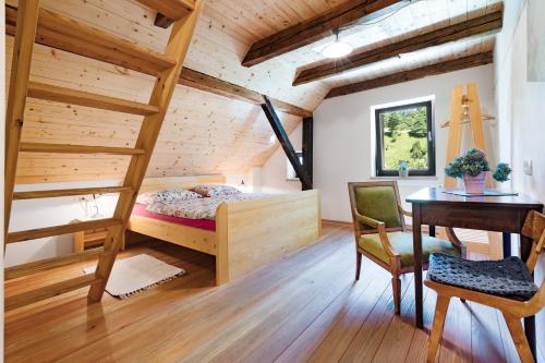 - une chambre avec des lits superposés, un bureau et une table dans l'établissement Homestead farm Tešnak, à Gorenja Vas