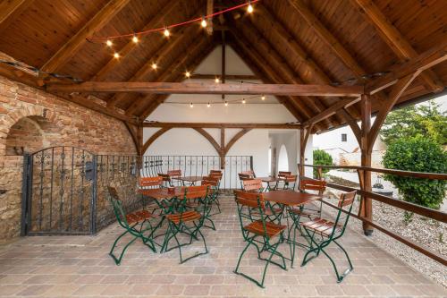 a patio with tables and chairs under a wooden roof at Dům Přátel Pavlova in Pavlov