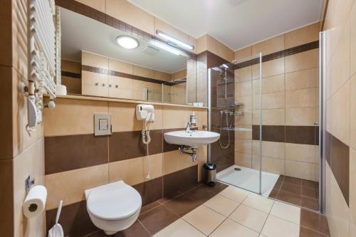 a bathroom with a toilet and a sink and a shower at Olympic Park I, Sun & Snow in Kołobrzeg