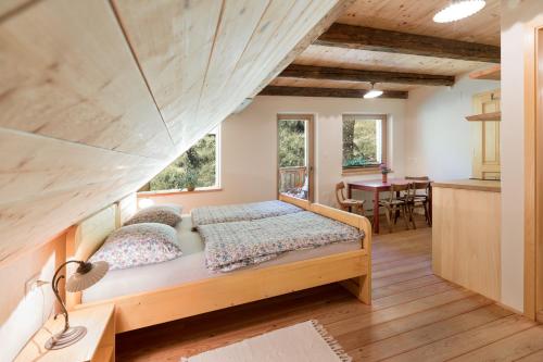 1 dormitorio con 1 cama y cocina con mesa en Homestead farm Tešnak, en Gorenja Vas