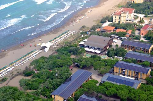an aerial view of a beach with buildings and a beach at Canado Club Family Village in Marina di Castagneto Carducci