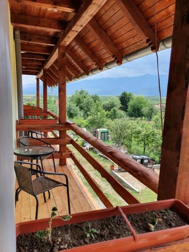 a wooden deck with a table and chairs on it at PENSIUNEA LEIA Transfăgărășan in Cîrţişoara