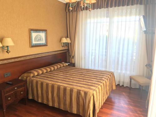a hotel room with a bed and a window at Hotel Begoña Park in Gijón