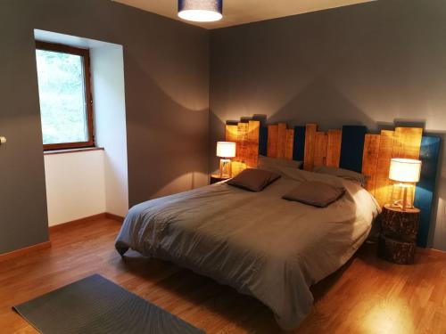 a bedroom with a large bed with two lamps at Gîte des 3 vallées in Baume-les-Messieurs