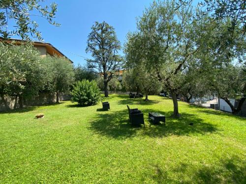 a park with benches and trees in the grass at Rooms ai Poggi in Bardolino