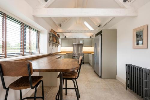 a kitchen with a wooden table and some chairs at The Sail House in Wighton