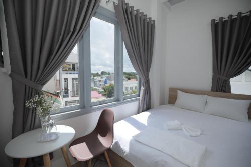 a bedroom with a white bed and a window at M Hotel Đà Lạt in Da Lat