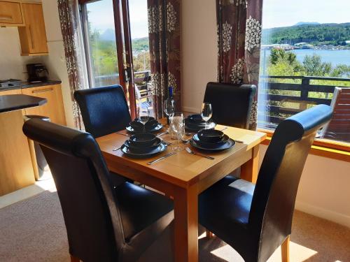 a dining room table with chairs and a table with glasses on it at Caisteal Liath in Lochinver