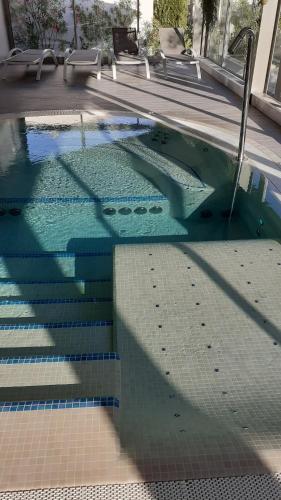 a swimming pool with a reflection in the water at Hôtel Villa Glanum et Spa in Saint-Rémy-de-Provence