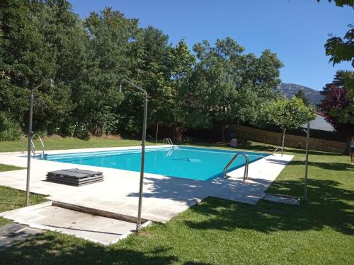 een zwembad in een tuin met twee lichten bij La Casita de la Sierra Cercedilla in Cercedilla