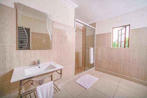 y baño con lavabo y ducha. en Khayalami Hotel - Mbombela, en Nelspruit