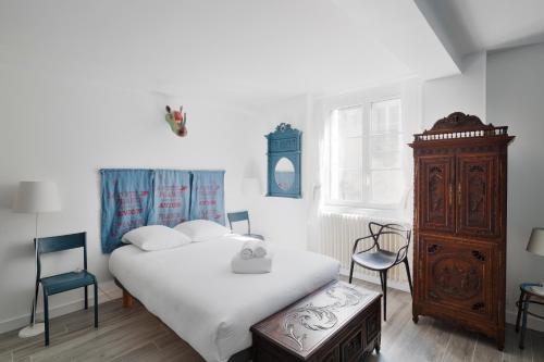 um quarto com uma cama branca e uma cómoda em madeira em Le Blue Note by Cocoonr - Bel appartement de standing em Saint Malo