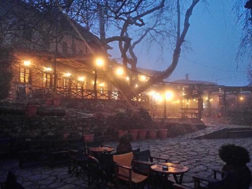 a patio with tables and lights in front of a building at Petrino in Palaios Panteleimonas