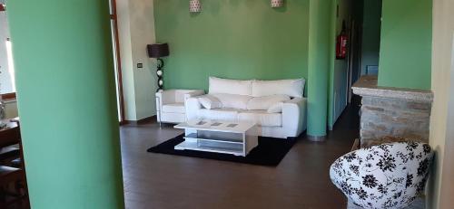 a living room with a white couch and a table at Casa Rural FULGUERA in El Espino
