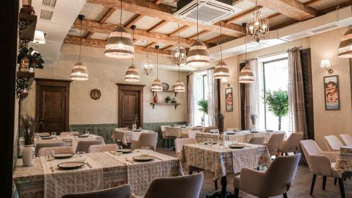 a dining room with tables and chairs and chandeliers at 7 Boutique Hotel in Ustʼ-Kamenogorsk