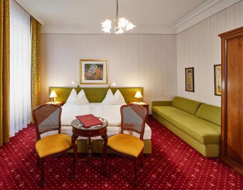 a hotel room with a bed and a couch at Hotel Austria - Wien in Vienna