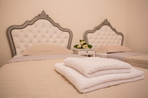 a bedroom with two beds with white towels on them at Pistakion Houses in Aegina Town
