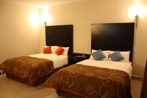 モコパネにあるOasis Hotelのベッド2台と枕2つが備わるホテルルームです。
