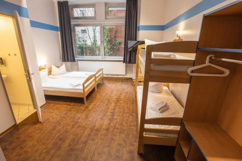 a dorm room with two bunk beds and a window at acama Hotel & Hostel Kreuzberg in Berlin