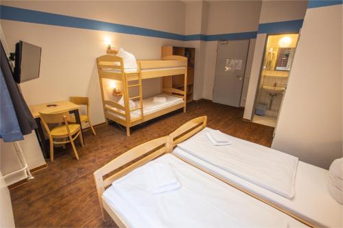 a small room with a bunk bed and a table at acama Hotel & Hostel Kreuzberg in Berlin