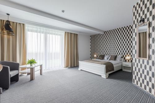 pokój hotelowy z łóżkiem i kanapą w obiekcie Jeleń Resort&Spa w mieście Jeleń