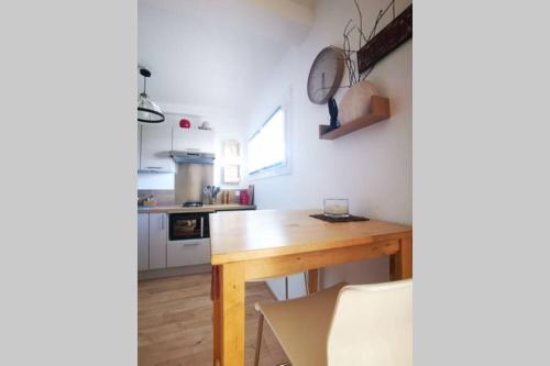 a kitchen with a wooden table in a room at Cocon - 2pers - parking - aéroport - MEET in Blagnac