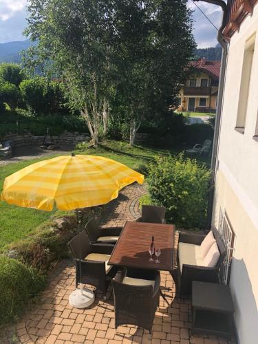 a table and chairs with an umbrella on a patio at Ferienhaus Schaller am Galsterberg in Pruggern