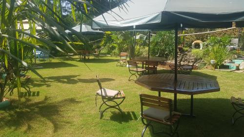 a patio with tables and chairs and an umbrella at Ashville Homes Meru in Meru