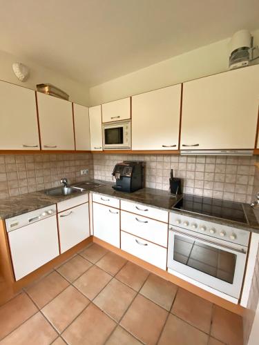 a kitchen with white cabinets and a microwave at Ferienhaus Schaller am Galsterberg in Pruggern