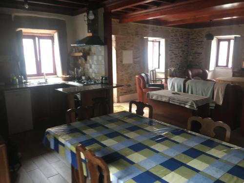 a kitchen and dining room with a table and a couch at Casadaldeiadalmofala in Almofala