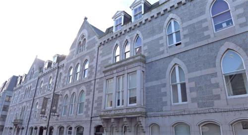 a large brick building with many windows on it at Carmelite Hotel in Aberdeen