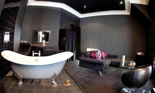 a bath room with a tub and a sink at Carmelite Hotel; BW Signature Collection in Aberdeen