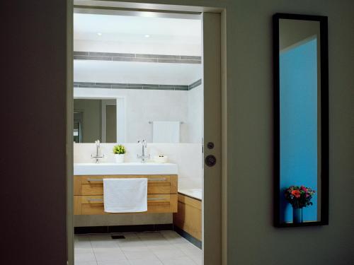 a bathroom with a sink and a mirror at Atlantic Suites Serviced Apartments in Gibraltar