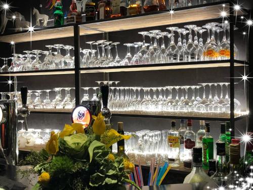 une étagère remplie de verres à vin et de bouteilles de vin dans l'établissement Haras des Chartreux, à Estaimbourg