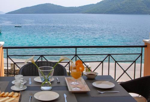 a table with food and a view of the water at Captain Nick Aparthotel in Mikros Gialos