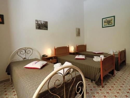 um quarto com 2 camas e guardanapos vermelhos em casa vicino mare ( sea rocks cottage) em Marina di Mancaversa