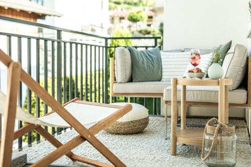 a balcony with a couch and a chair at Oskar Apartments in Neustift im Stubaital