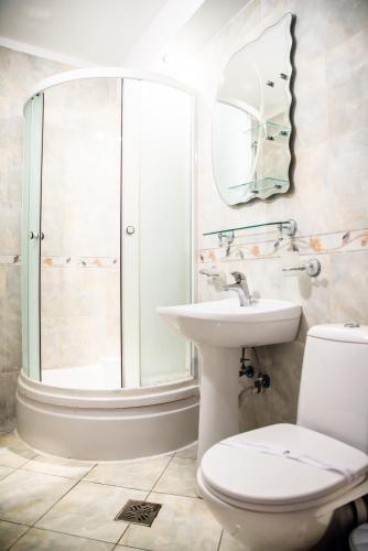 a bathroom with a shower and a toilet and a sink at Club Onix Apartments in Neptun