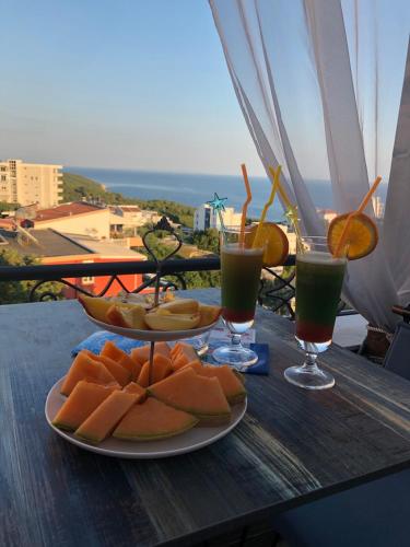 a table with two plates of food and two glasses of juice at Padam Hotel & SPA in Ulcinj