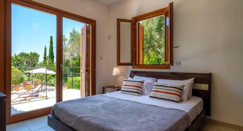 a bedroom with a bed and a large window at 4 bedroom Villa Lofou with private pool and sea views, Aphrodite Hills Resort in Kouklia