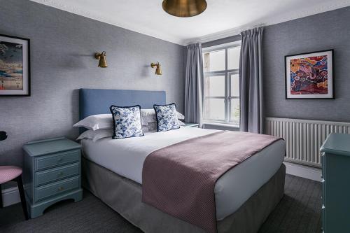 um quarto com uma cama grande e uma janela em Craig Manor em Bowness-on-Windermere