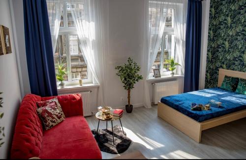 a bedroom with a bed and a couch and windows at Apartamenty Centrum in Bydgoszcz