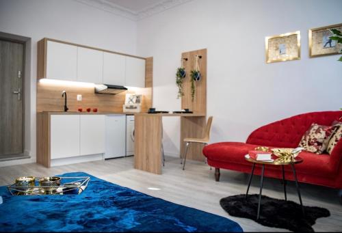 a living room with a red couch and a table at Apartamenty Centrum in Bydgoszcz
