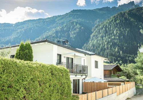 a white house with mountains in the background at Oskar Apartments in Neustift im Stubaital